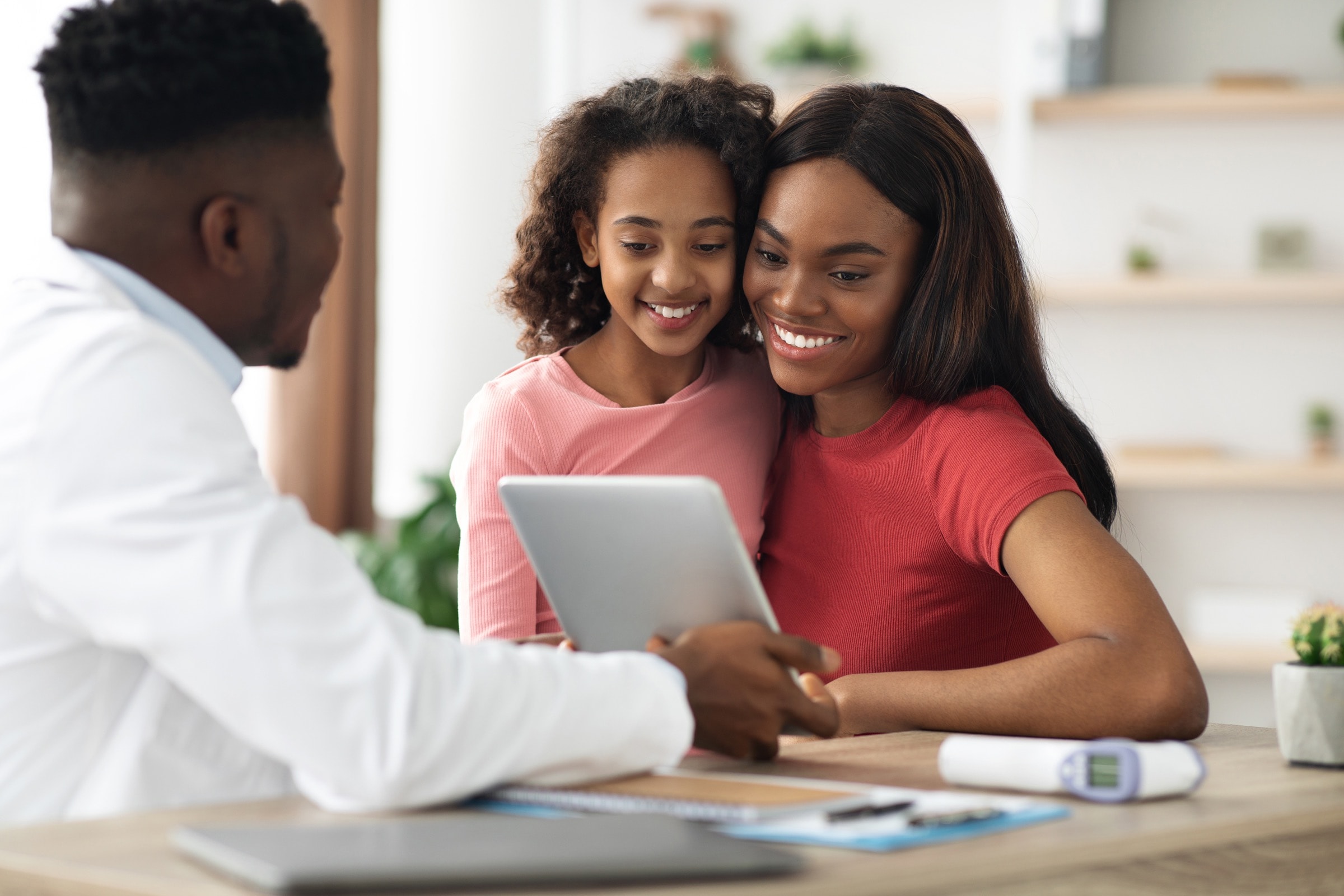 A smiling family talking with their doctor